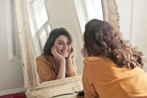 A Woman Staring Happily at Her Mirror Image A Woman Staring Happily at Her Mirror Image